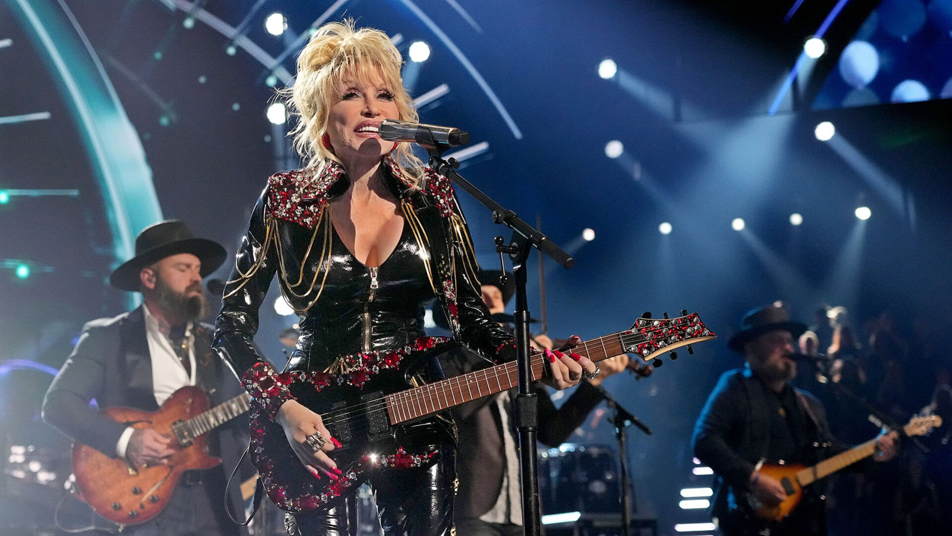 Dolly Parton jokes she’ll ‘hopefully drop dead in the middle of a song’ someday before she ever retires